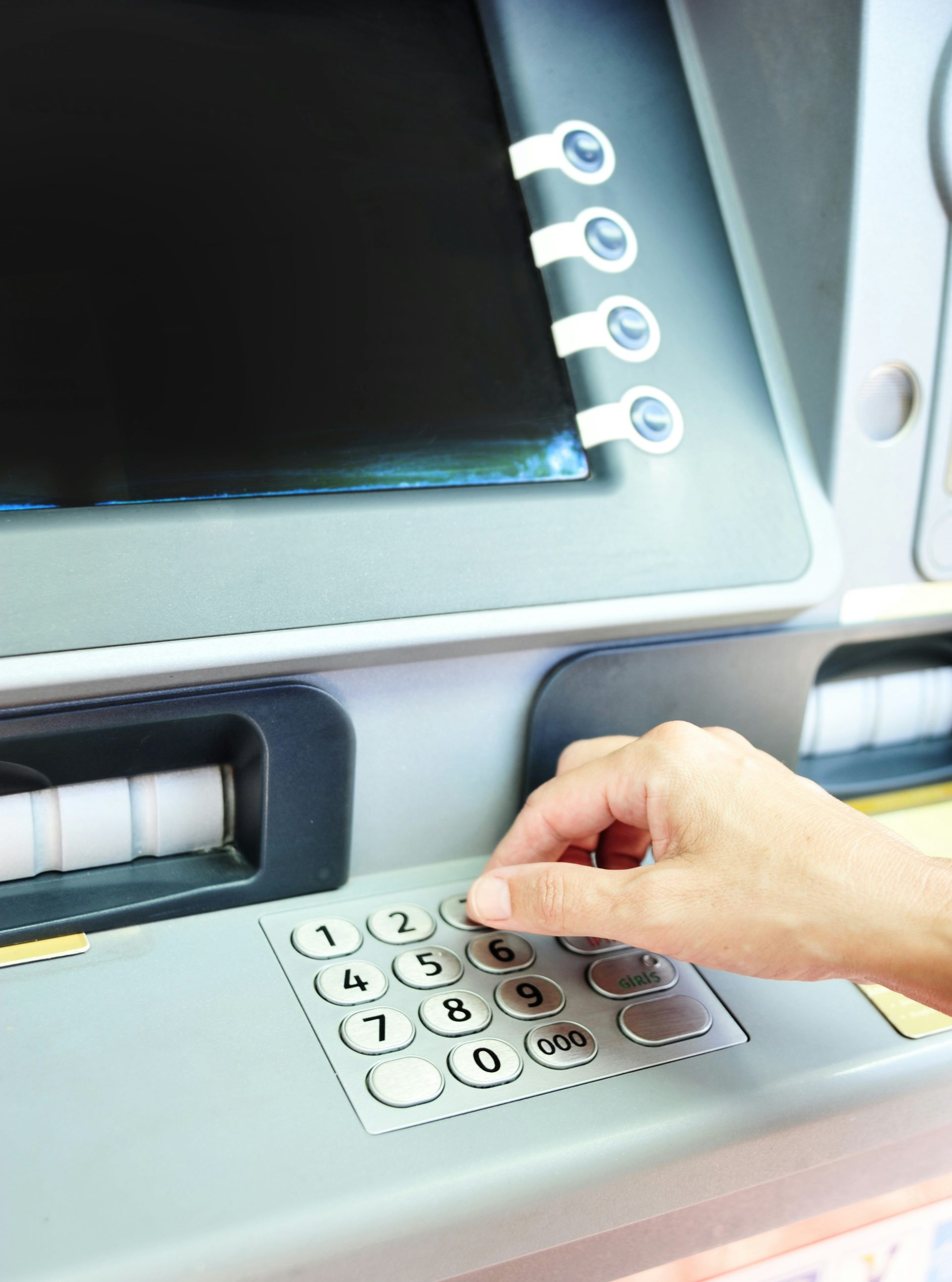 Hand using keypad on an atm machine.